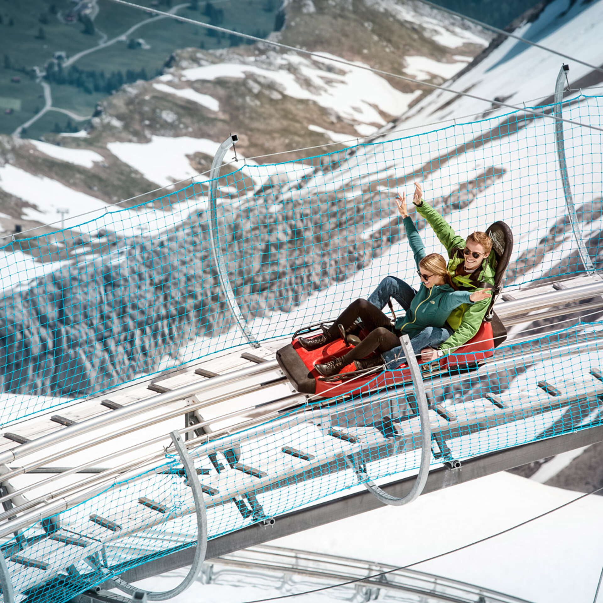Zwei Personen die Spass haben auf dem Alpine Coaster auf dem Glacier3000.