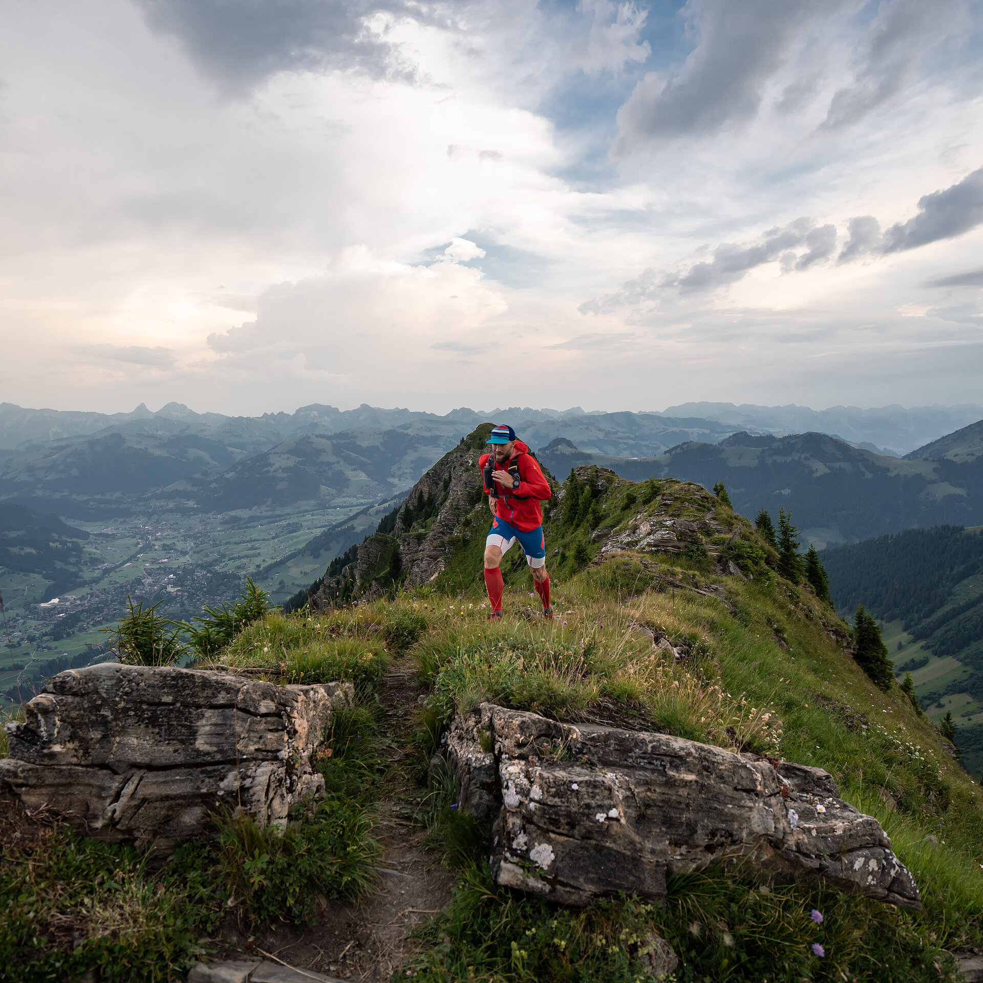 Person in roter Kleidung rennt auf einem Wanderweg den Berg hoch.