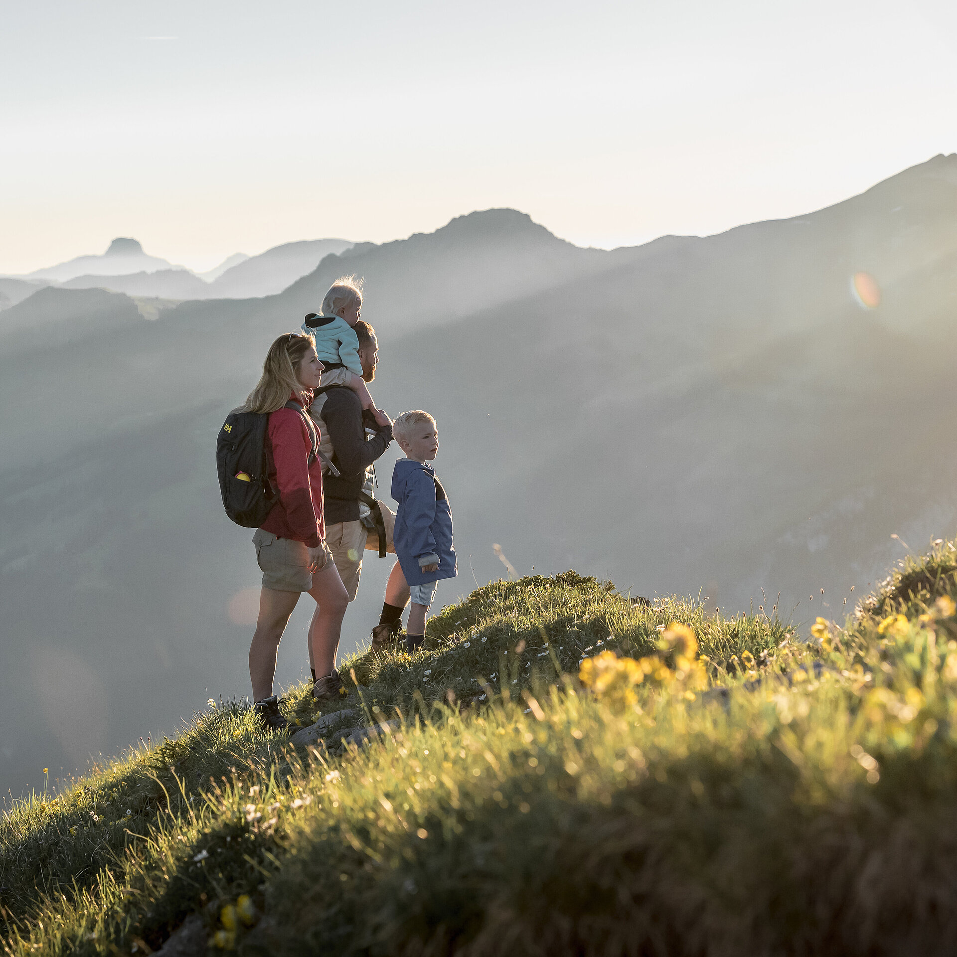 Familie mit zwei kleinen Kinder schauen das Panorama mit speziellem Sonnenlicht