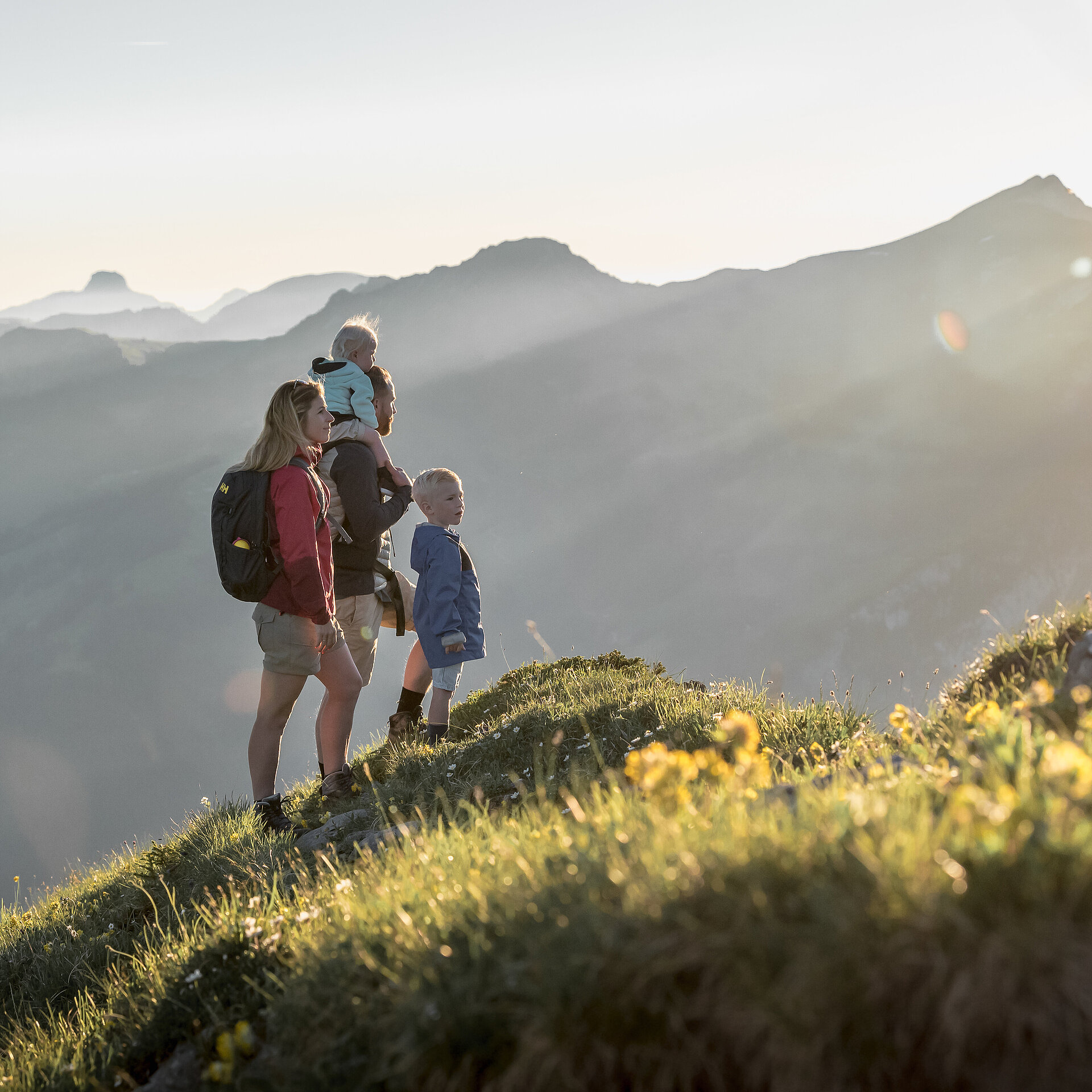 Familie mit zwei kleinen Kinder schauen das Panorama mit speziellem Sonnenlicht