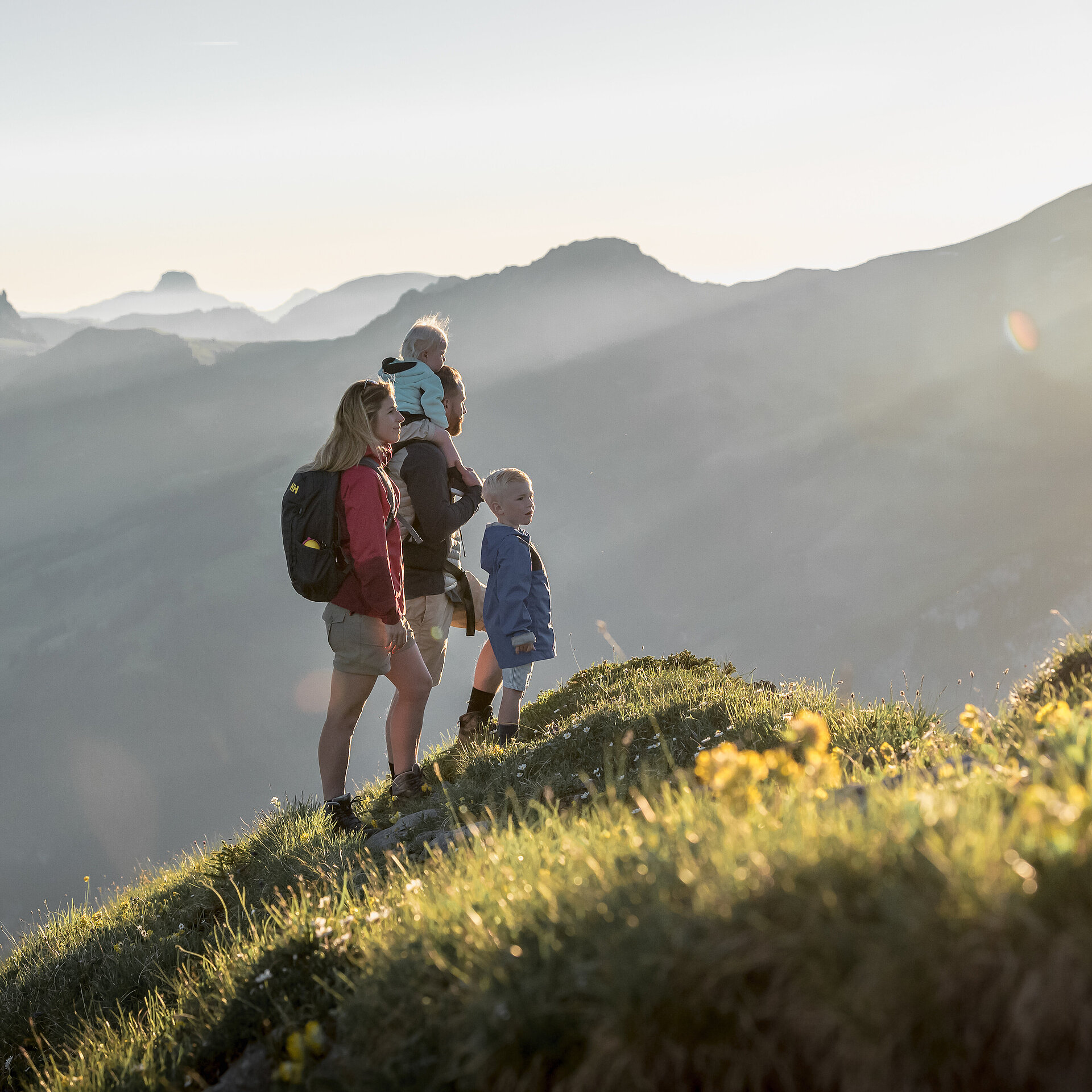 Familie mit zwei kleinen Kinder schauen das Panorama mit speziellem Sonnenlicht