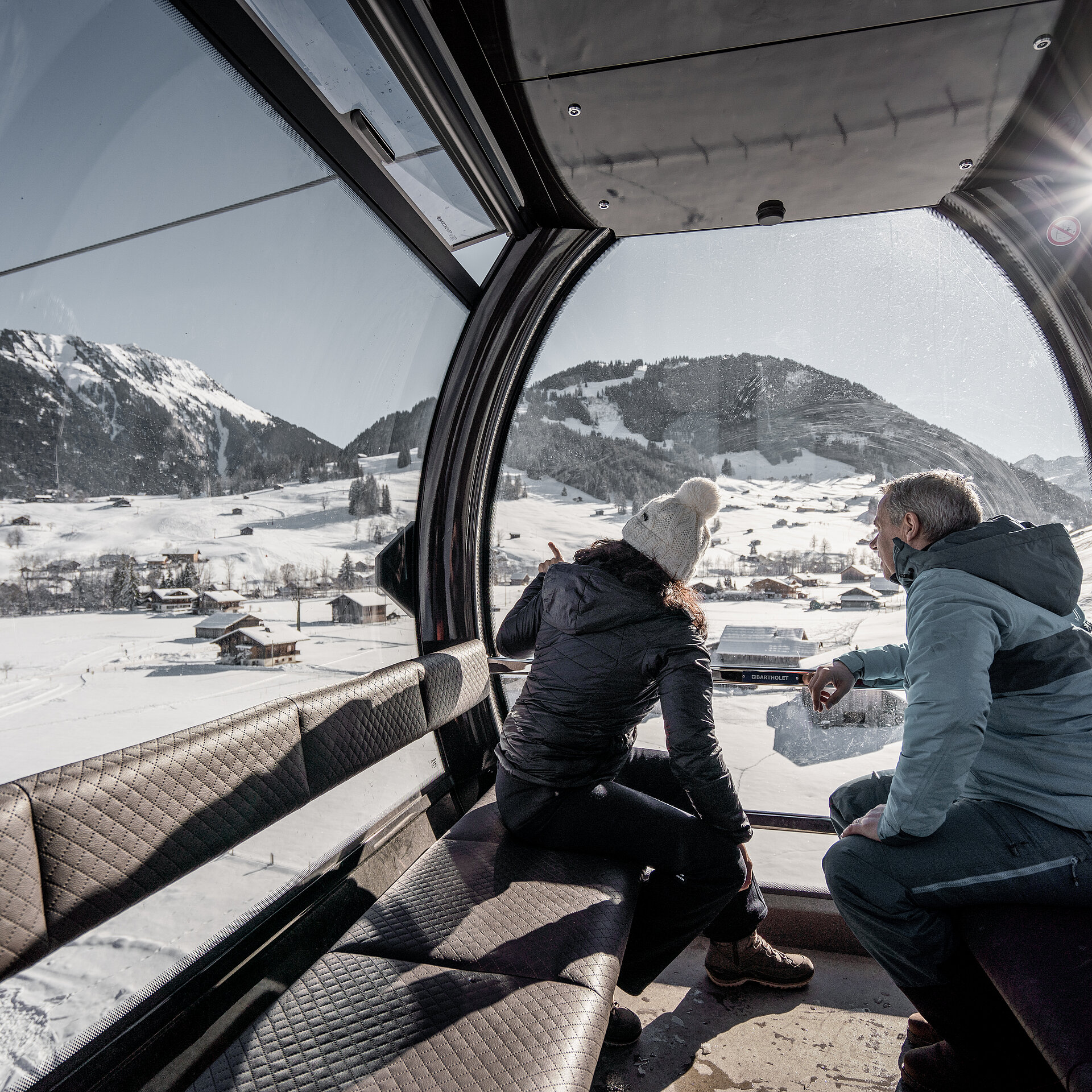 Zwei Personen fahren im Winter mit der Gondelbahn aufs Eggli.