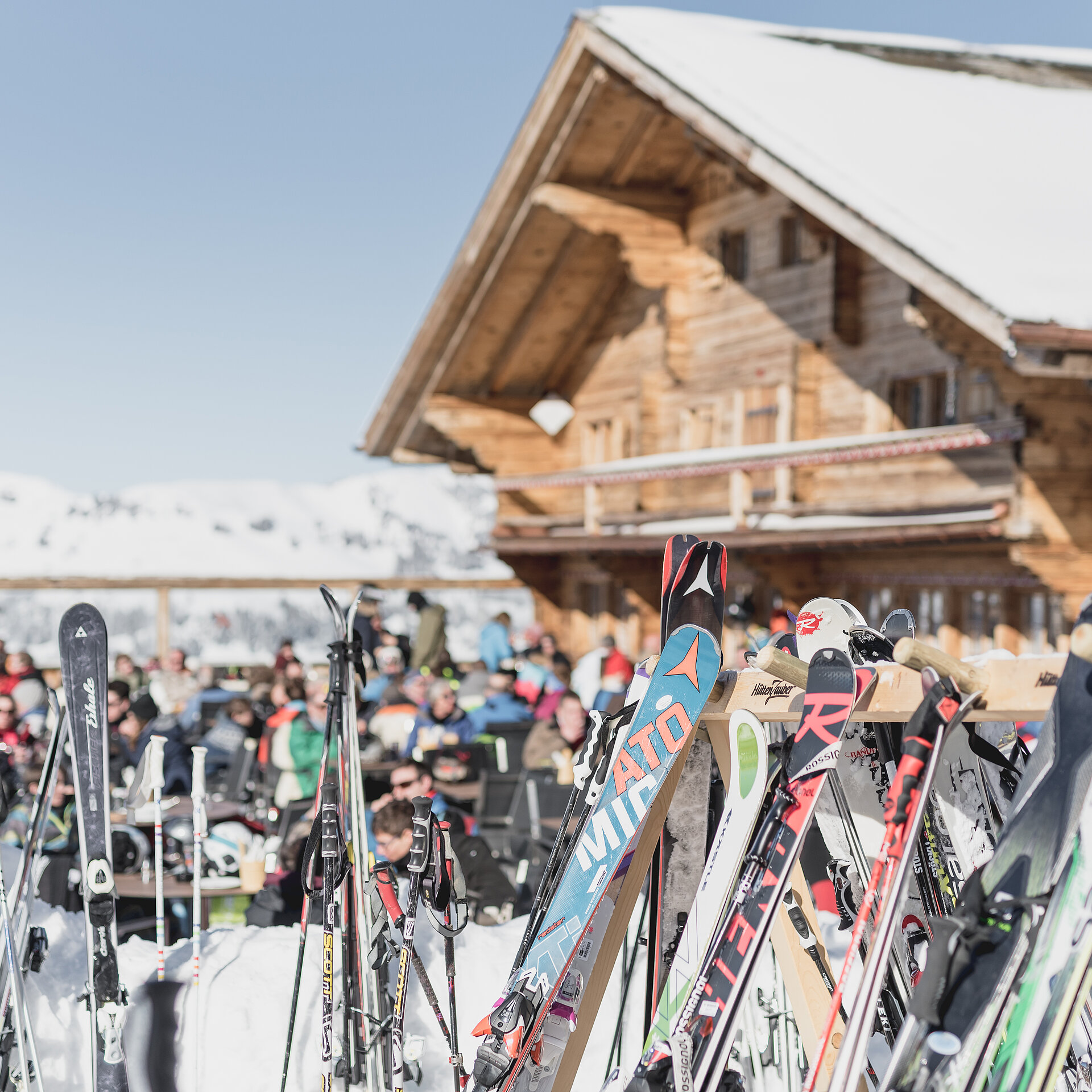 Berghaus auf dem Horneggli mit vielen bunten Skier davor.