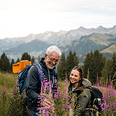 Eine Dame und ein Herr beim Bestaunen der Flora und Fauna auf dem Berg.