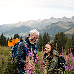 Eine Dame und ein Herr beim Bestaunen der Flora und Fauna auf dem Berg.