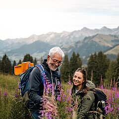 Eine Dame und ein Herr beim Bestaunen der Flora und Fauna auf dem Berg.