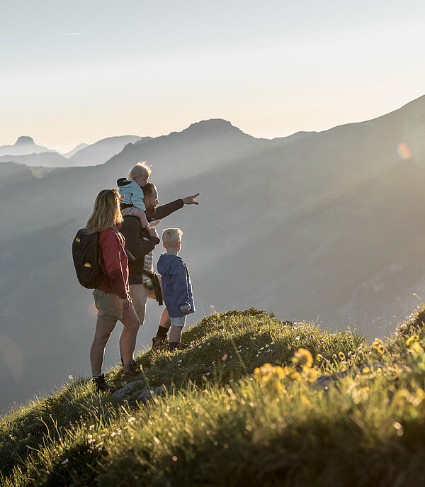 Eine Familie geniesst die Aussicht am Rinderberg.