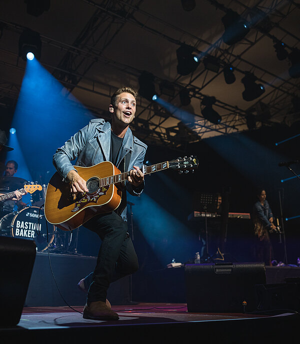 Sebastian Baker singt und spielt mit der Band auf der Bühne am Country Night Gstaad.