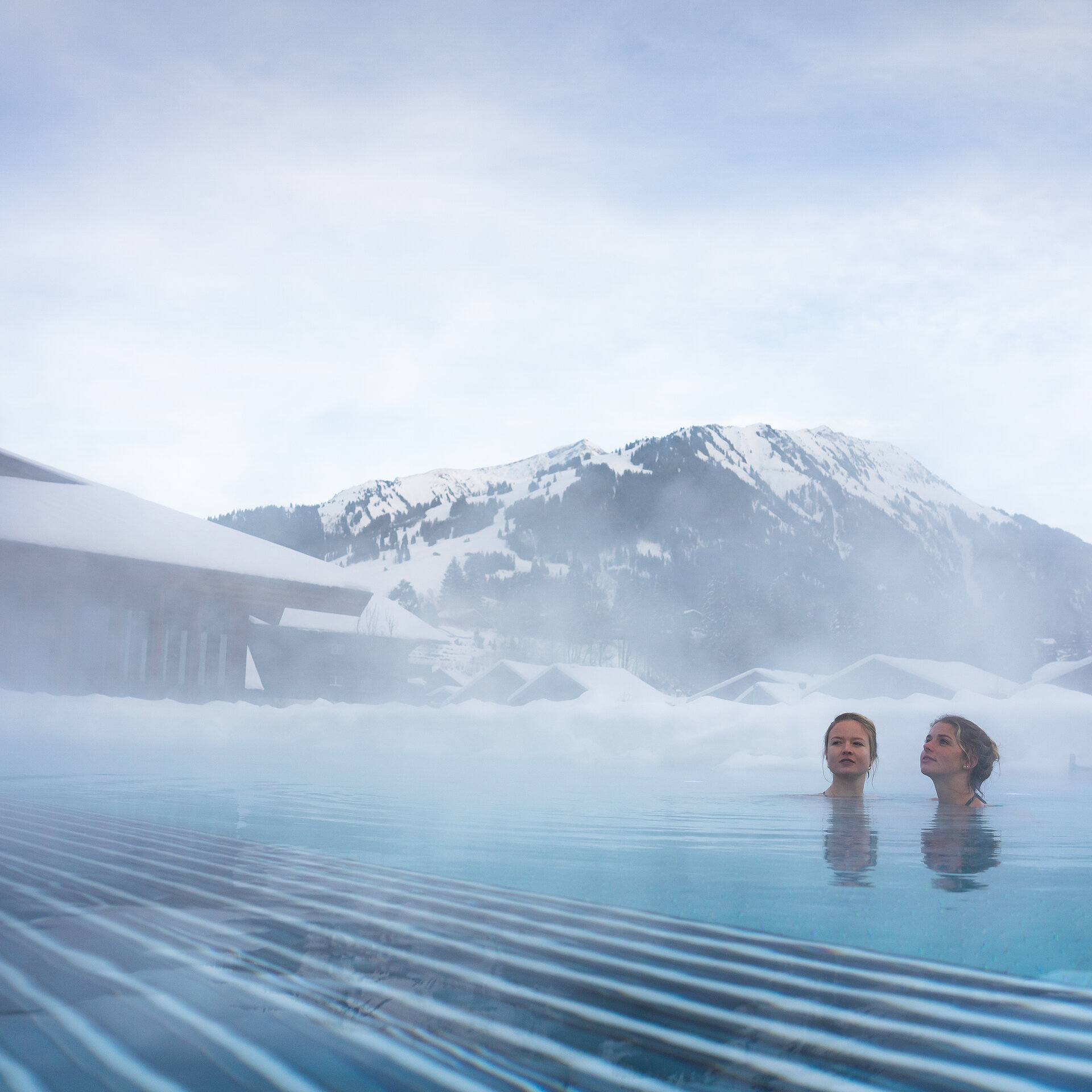 Pool mit Dampf und zwei Frauen die entspannen.